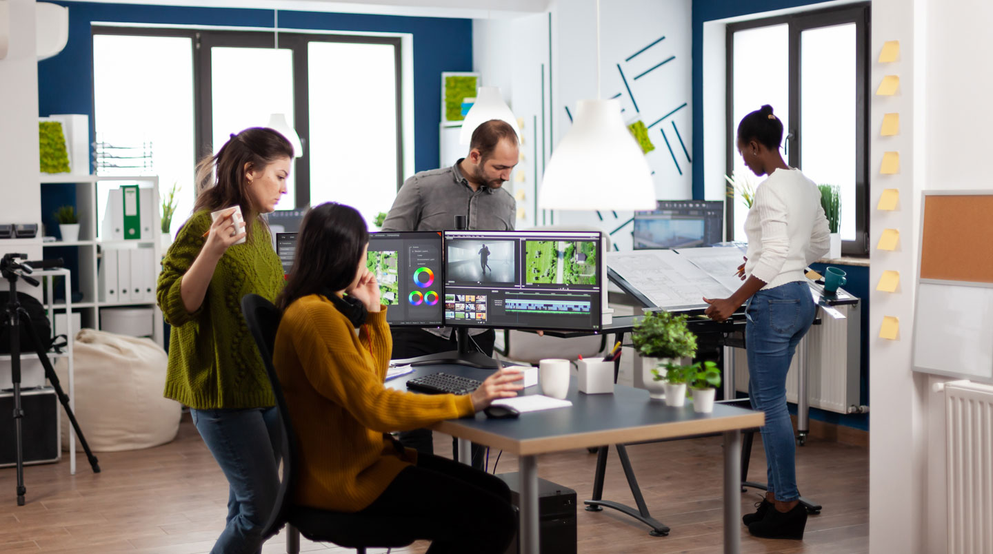 Modern corporate meeting room with glass partition walls and a large presentation display screen, empty chairs around conference table, clean contemporary office design
